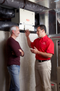 Certified HVAC maintenance service provider explaining common AC problems to a homeowner.