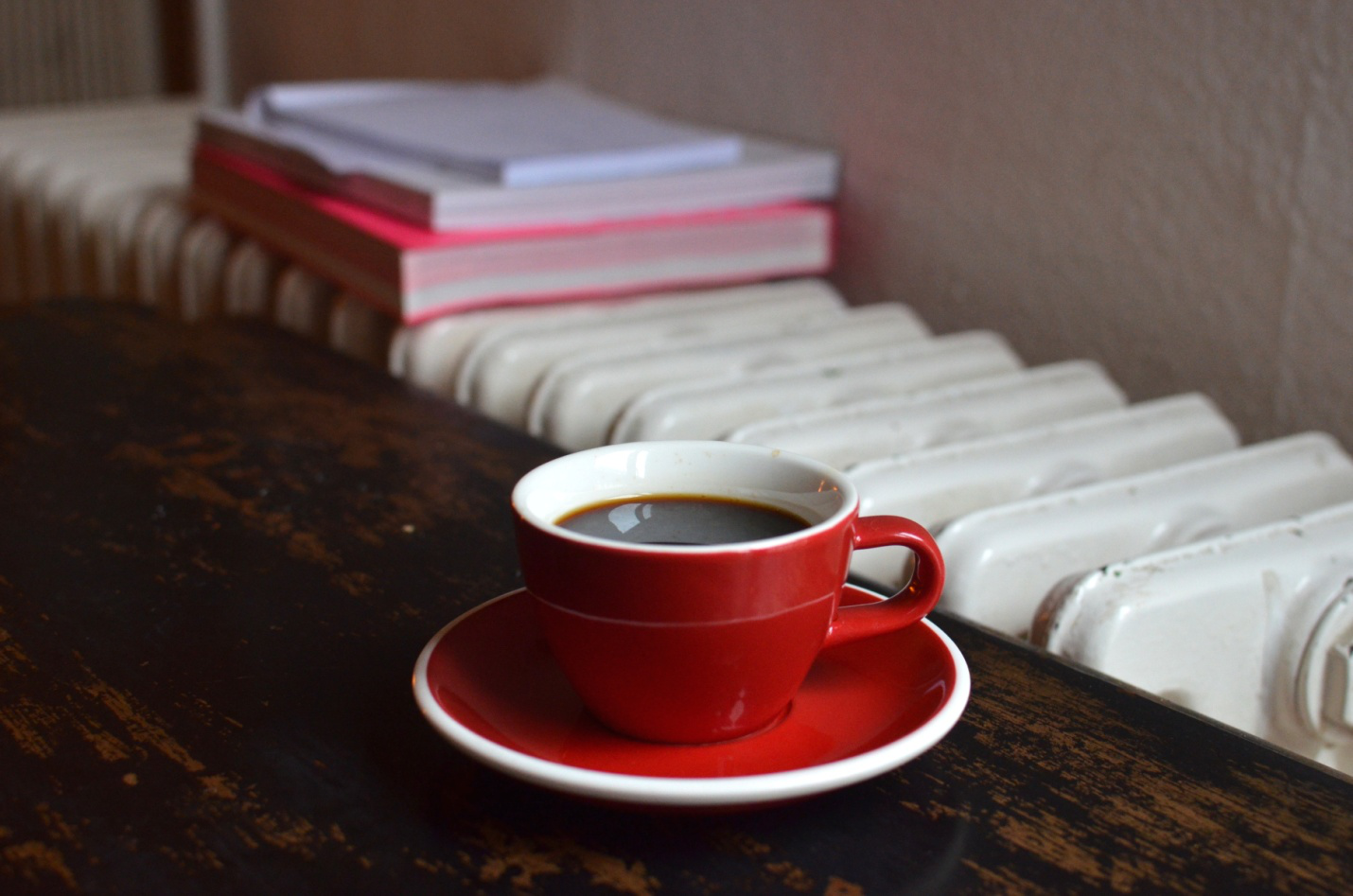 A cup of coffee on the table near a heating system.